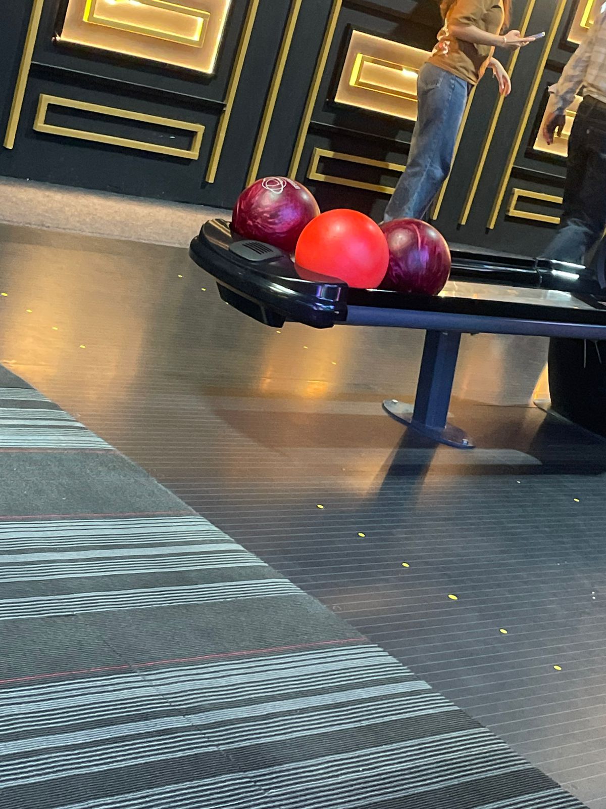 Bowling ball return machine and bowling lanes