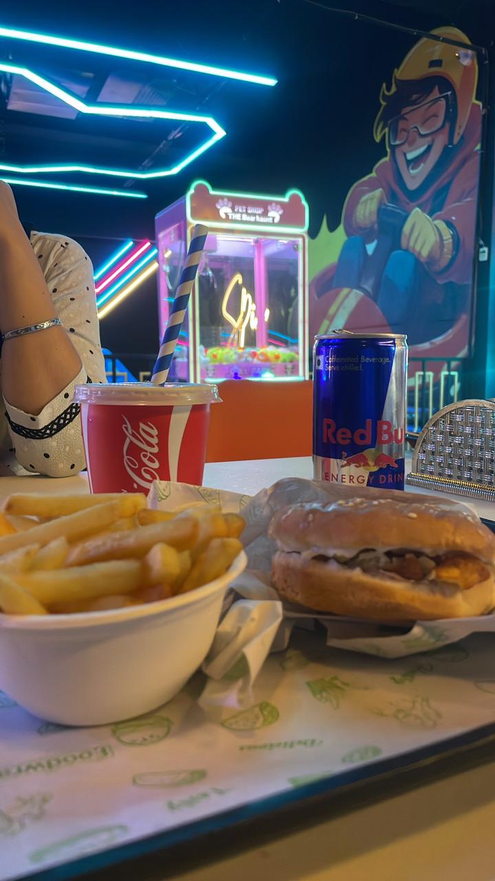 Burger, fries and drinks with arcade neon backdrop