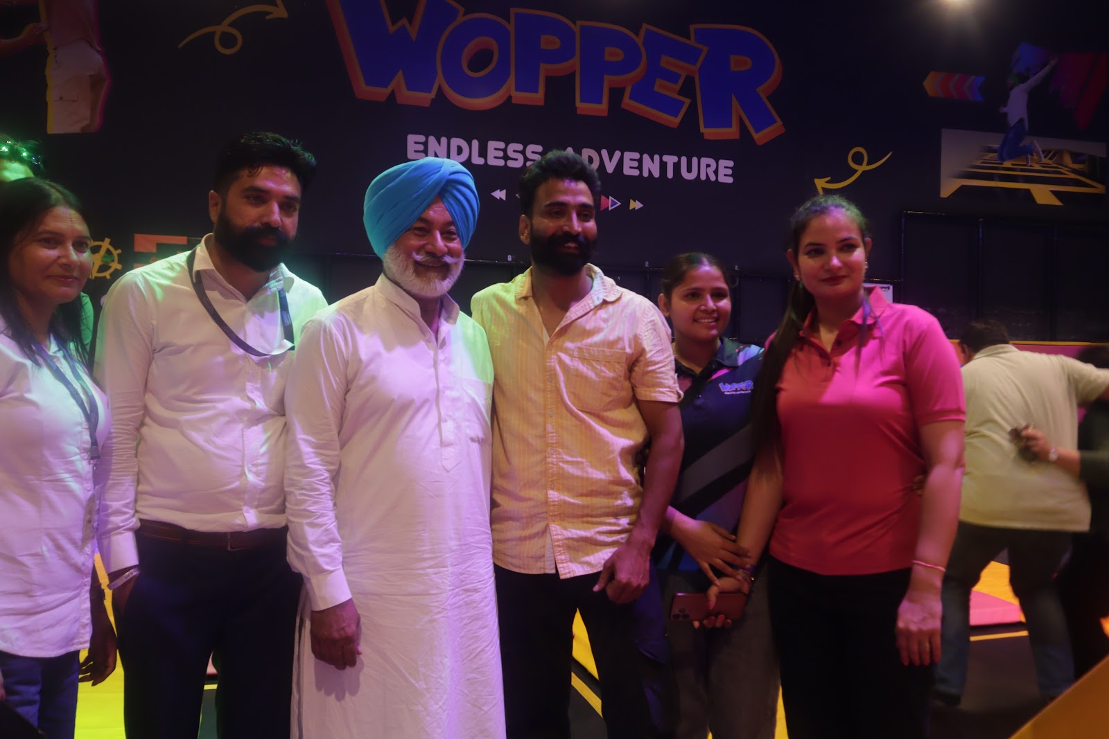 Group gathering in front of Wopper Endless Adventure wall