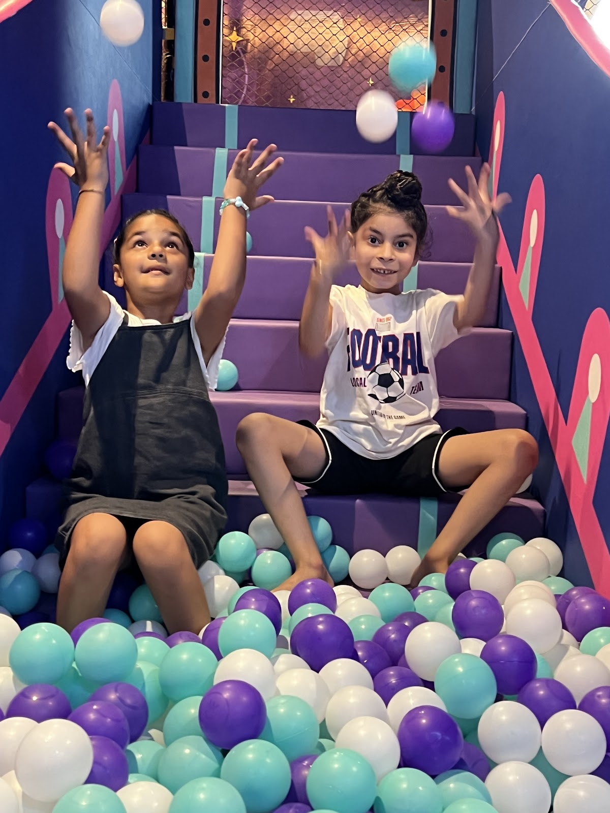 Kids playing on soft play steps in the ball pit