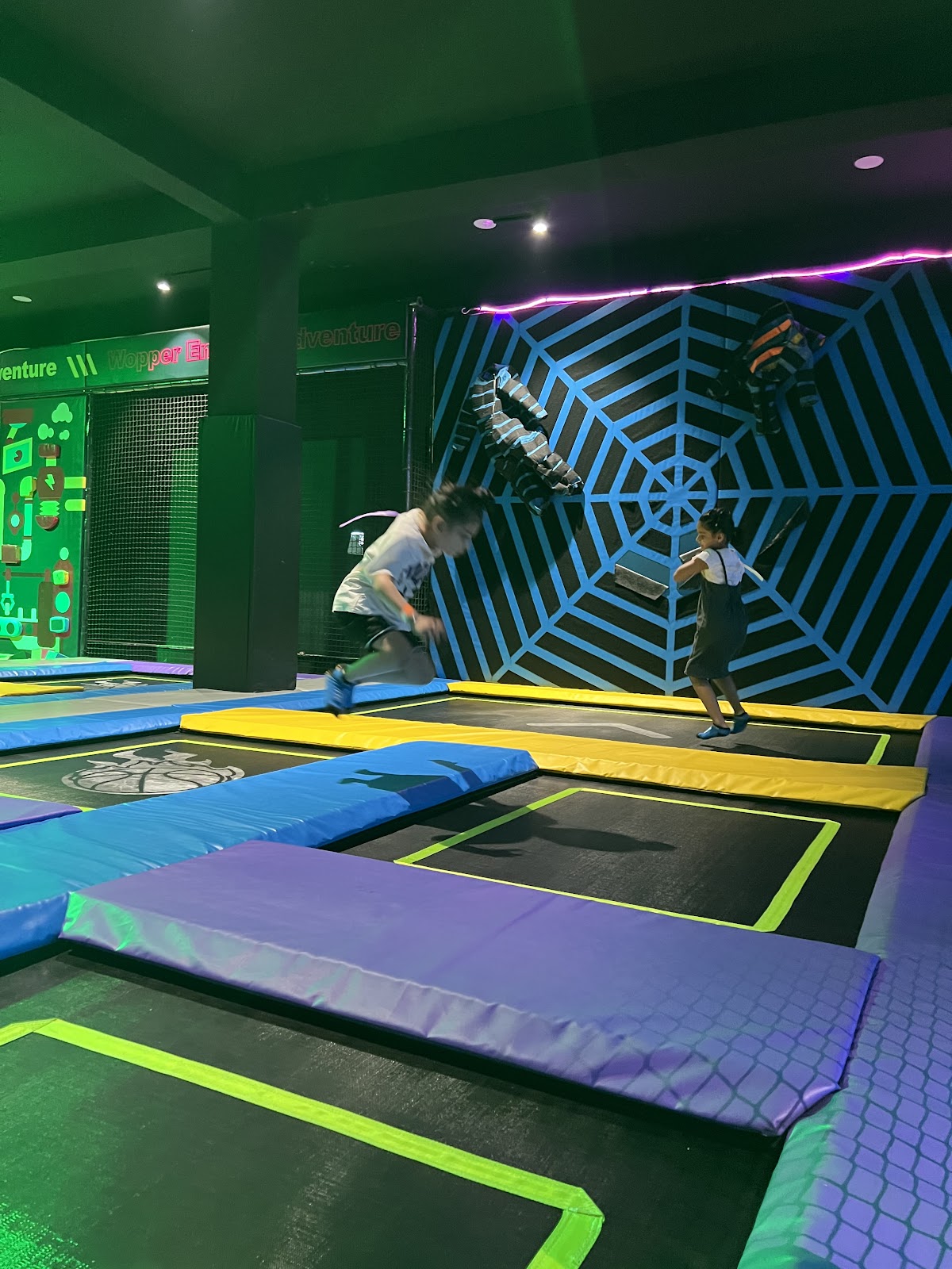 Kids jumping high on trampoline mats